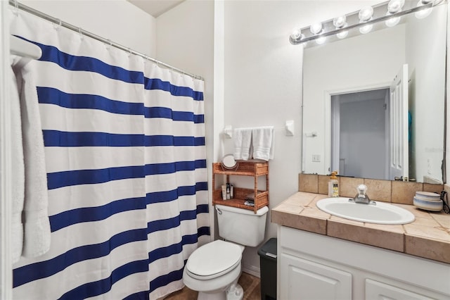 bathroom with vanity, curtained shower, and toilet