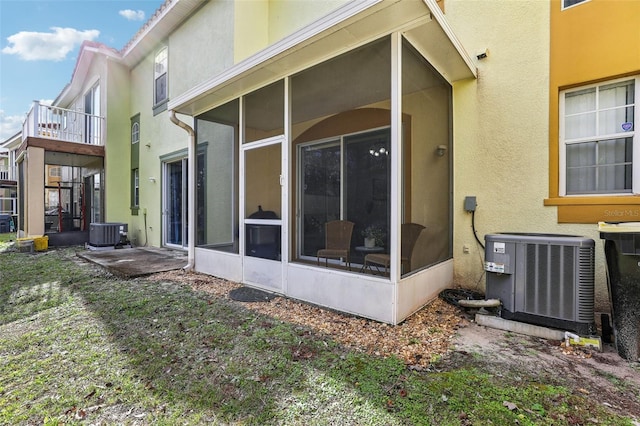 view of home's exterior featuring central AC unit, a sunroom, and a patio