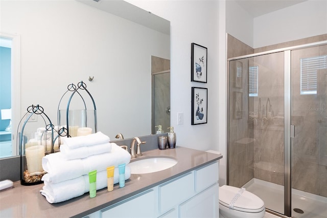 bathroom with vanity, toilet, and a shower with shower door