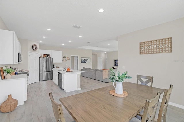 dining space featuring sink and light wood-type flooring