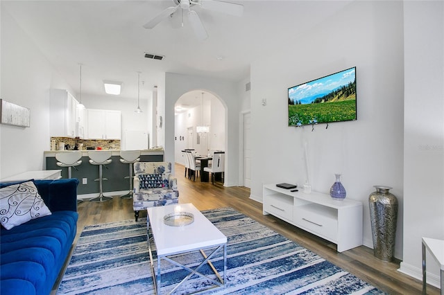 living room featuring dark wood-type flooring and ceiling fan