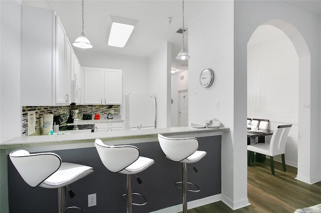 kitchen with white cabinetry, hanging light fixtures, and a breakfast bar area