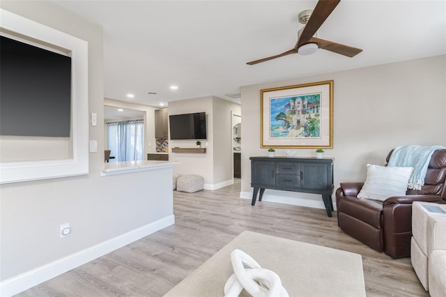 living room with light hardwood / wood-style flooring and ceiling fan