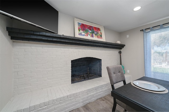 dining space featuring hardwood / wood-style flooring and a fireplace