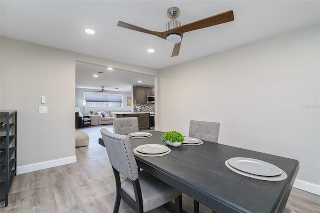 dining room with ceiling fan and light wood-type flooring