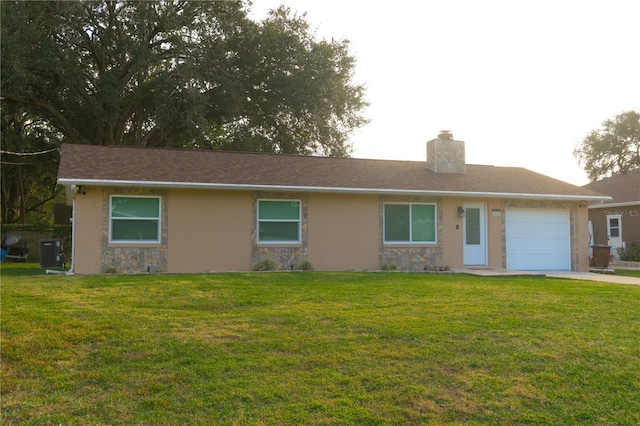 single story home featuring cooling unit, a garage, and a front yard