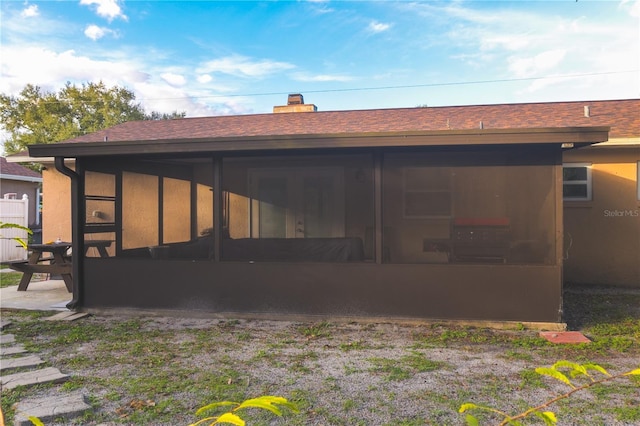 rear view of house featuring a sunroom