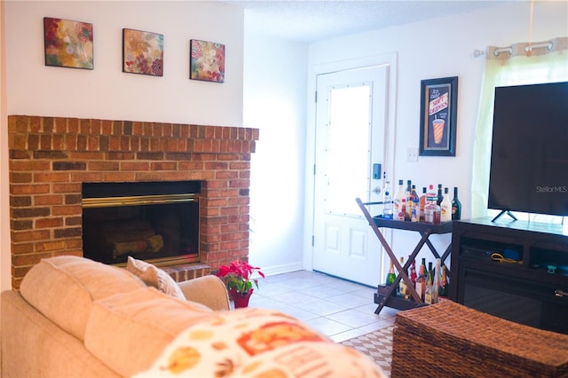 living room with a brick fireplace, a textured ceiling, and light tile patterned flooring