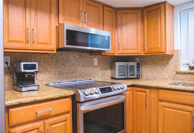 kitchen with backsplash, stainless steel appliances, and a wealth of natural light