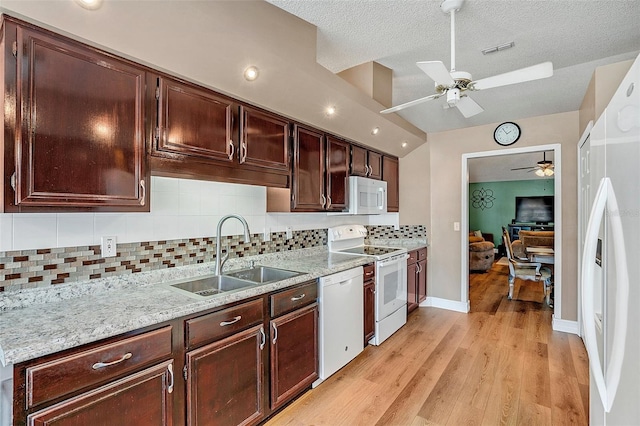 kitchen with sink, tasteful backsplash, light wood-type flooring, ceiling fan, and white appliances