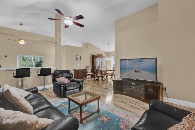 living room featuring ceiling fan, high vaulted ceiling, and light hardwood / wood-style floors