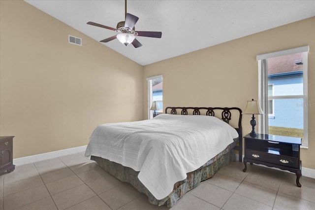 tiled bedroom featuring multiple windows, vaulted ceiling, and ceiling fan