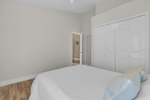 bedroom with hardwood / wood-style flooring, ceiling fan, and a closet