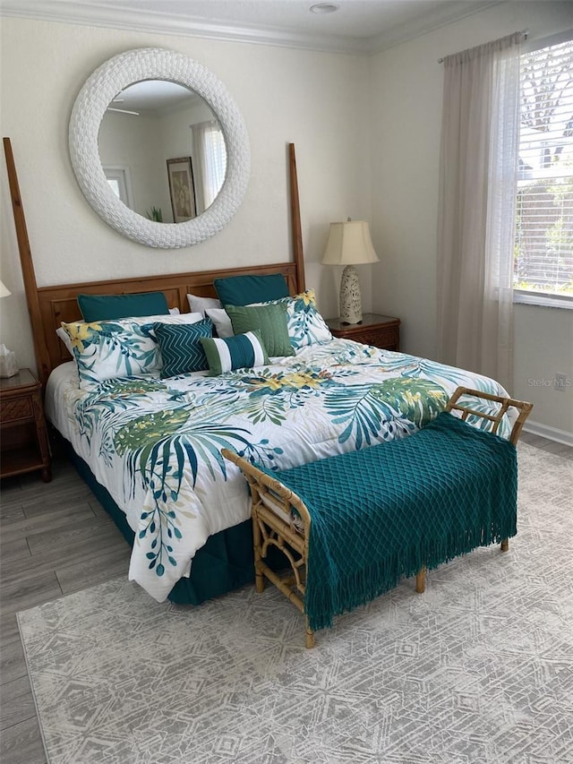 bedroom featuring ornamental molding and hardwood / wood-style floors