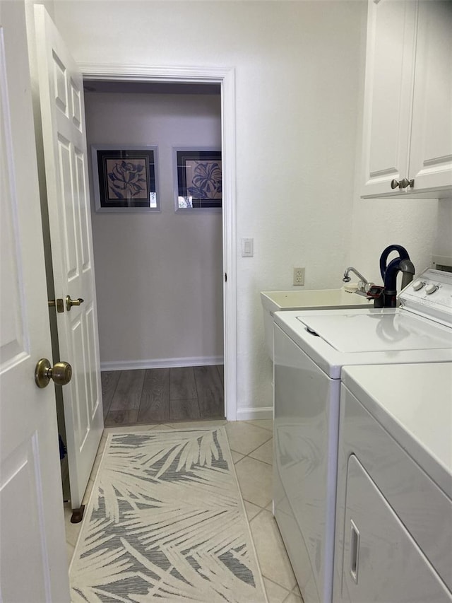 laundry room with cabinets, washing machine and dryer, and light tile patterned flooring