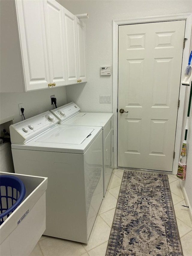 laundry area with cabinets, light tile patterned floors, and independent washer and dryer