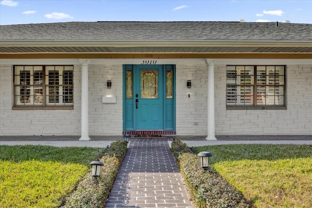 view of exterior entry with a lawn