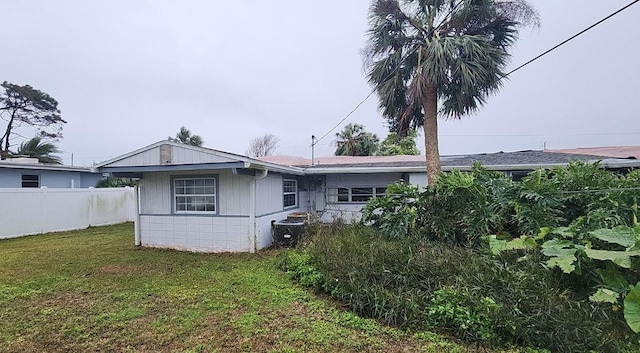 back of house featuring a yard and central AC unit