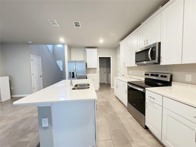 kitchen featuring sink, stainless steel appliances, an island with sink, and white cabinets