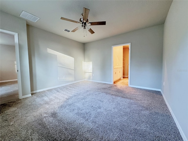 spare room featuring light carpet and ceiling fan