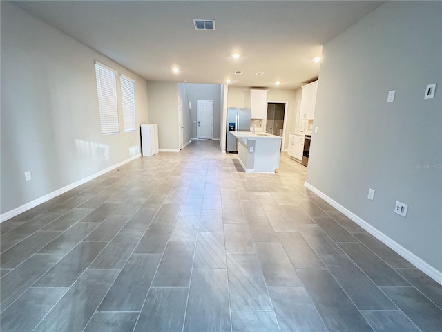 unfurnished living room featuring sink