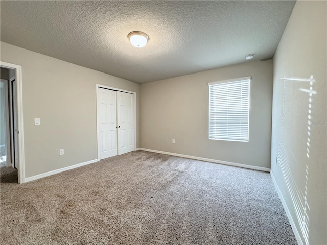 unfurnished bedroom with carpet floors, a textured ceiling, and a closet