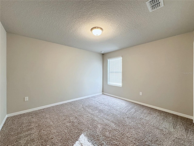 empty room featuring a textured ceiling and carpet