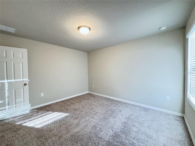 unfurnished room with carpet flooring and a textured ceiling