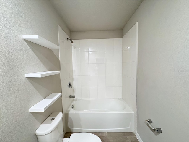 bathroom featuring tiled shower / bath combo and toilet