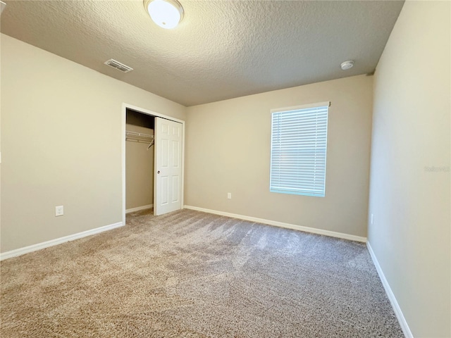 unfurnished bedroom featuring carpet, a closet, and a textured ceiling