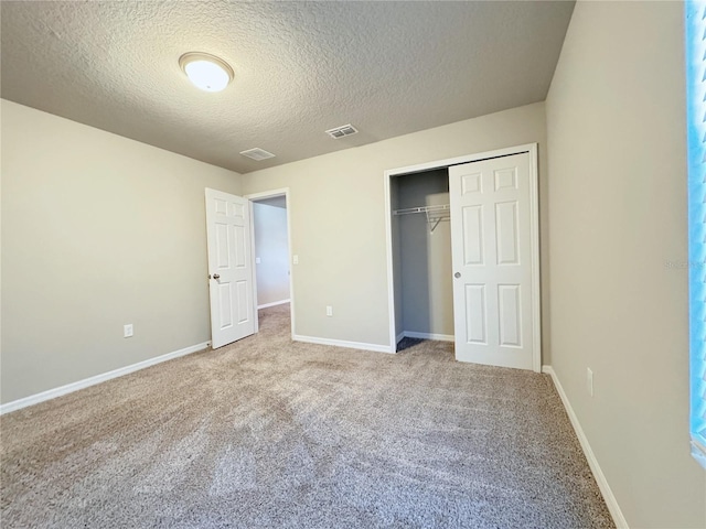 unfurnished bedroom featuring a closet, a textured ceiling, and carpet