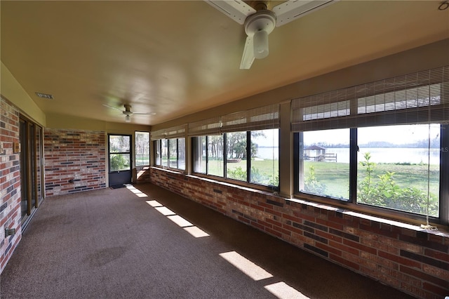 unfurnished sunroom featuring ceiling fan