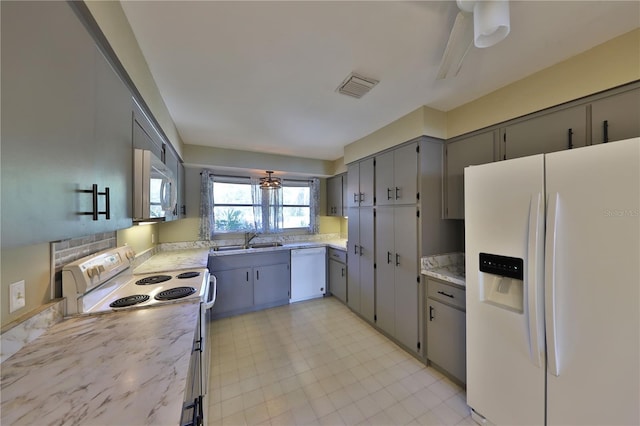 kitchen featuring gray cabinetry, sink, white appliances, and ceiling fan