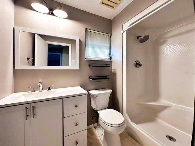 bathroom featuring tile patterned flooring, vanity, walk in shower, and toilet