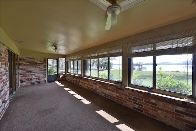 unfurnished sunroom with ceiling fan