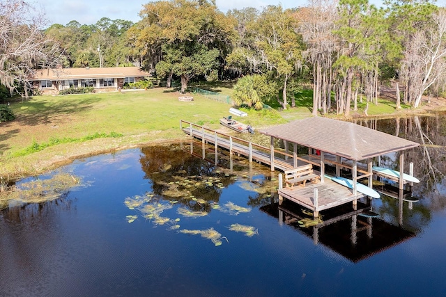 view of dock featuring a water view and a yard