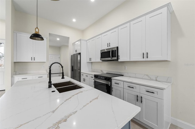 kitchen featuring decorative light fixtures, white cabinetry, sink, stainless steel appliances, and light stone countertops