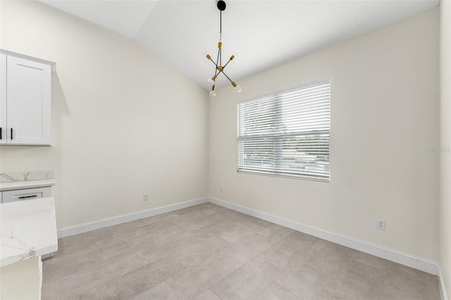 unfurnished dining area featuring an inviting chandelier and lofted ceiling