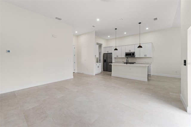 kitchen featuring pendant lighting, white cabinetry, sink, a kitchen island with sink, and black refrigerator with ice dispenser