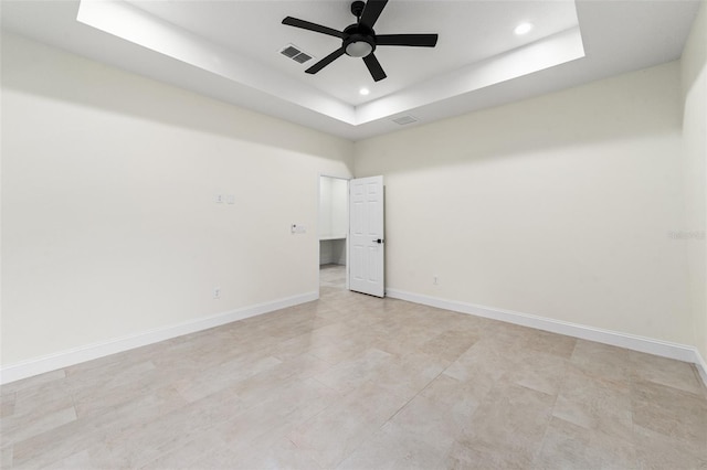 unfurnished room featuring ceiling fan and a tray ceiling