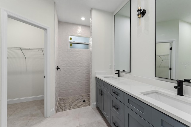 bathroom with vanity, tile patterned flooring, and a tile shower