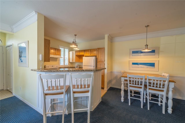 kitchen featuring crown molding, white refrigerator, kitchen peninsula, pendant lighting, and light colored carpet