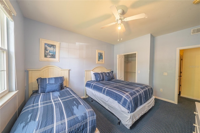 bedroom featuring vaulted ceiling, carpet, a spacious closet, ceiling fan, and a closet