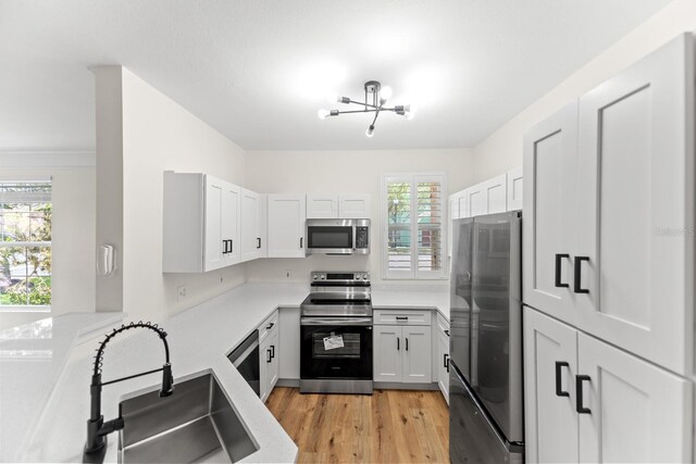 3013 Bonfire Beach Dr Unit 101, Kissimmee, FL 34746 - kitchen with stainless steel appliances, a sink, light countertops, and light wood-style floors