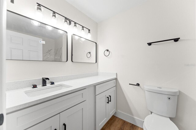 3013 Bonfire Beach Dr Unit 101, Kissimmee, FL 34746 - bathroom featuring vanity, toilet, wood finished floors, and baseboards
