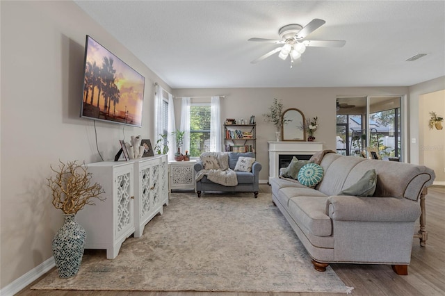 living room featuring hardwood / wood-style flooring, a textured ceiling, and ceiling fan