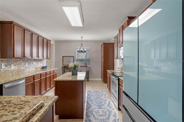 kitchen with light stone counters, tasteful backsplash, a center island, pendant lighting, and stainless steel appliances