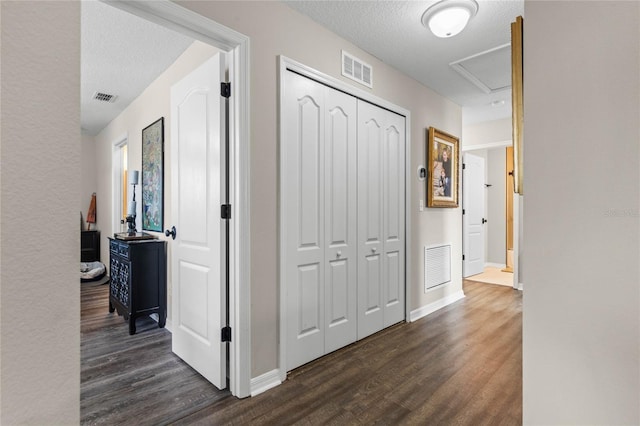 hallway featuring dark hardwood / wood-style flooring and a textured ceiling