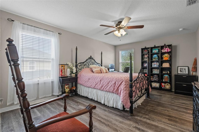 bedroom featuring ceiling fan, dark wood-type flooring, and a textured ceiling