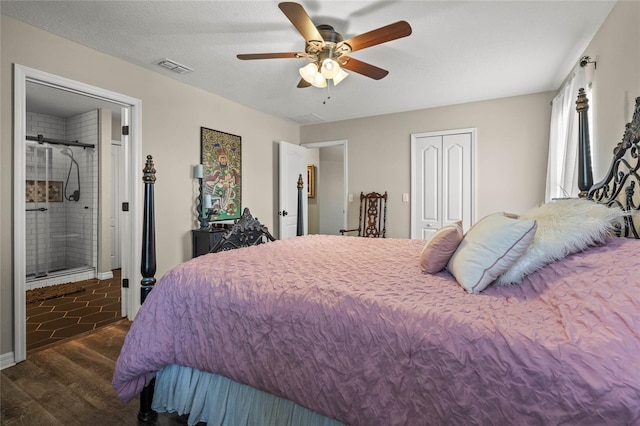 bedroom featuring ceiling fan, ensuite bathroom, a textured ceiling, dark hardwood / wood-style flooring, and a closet